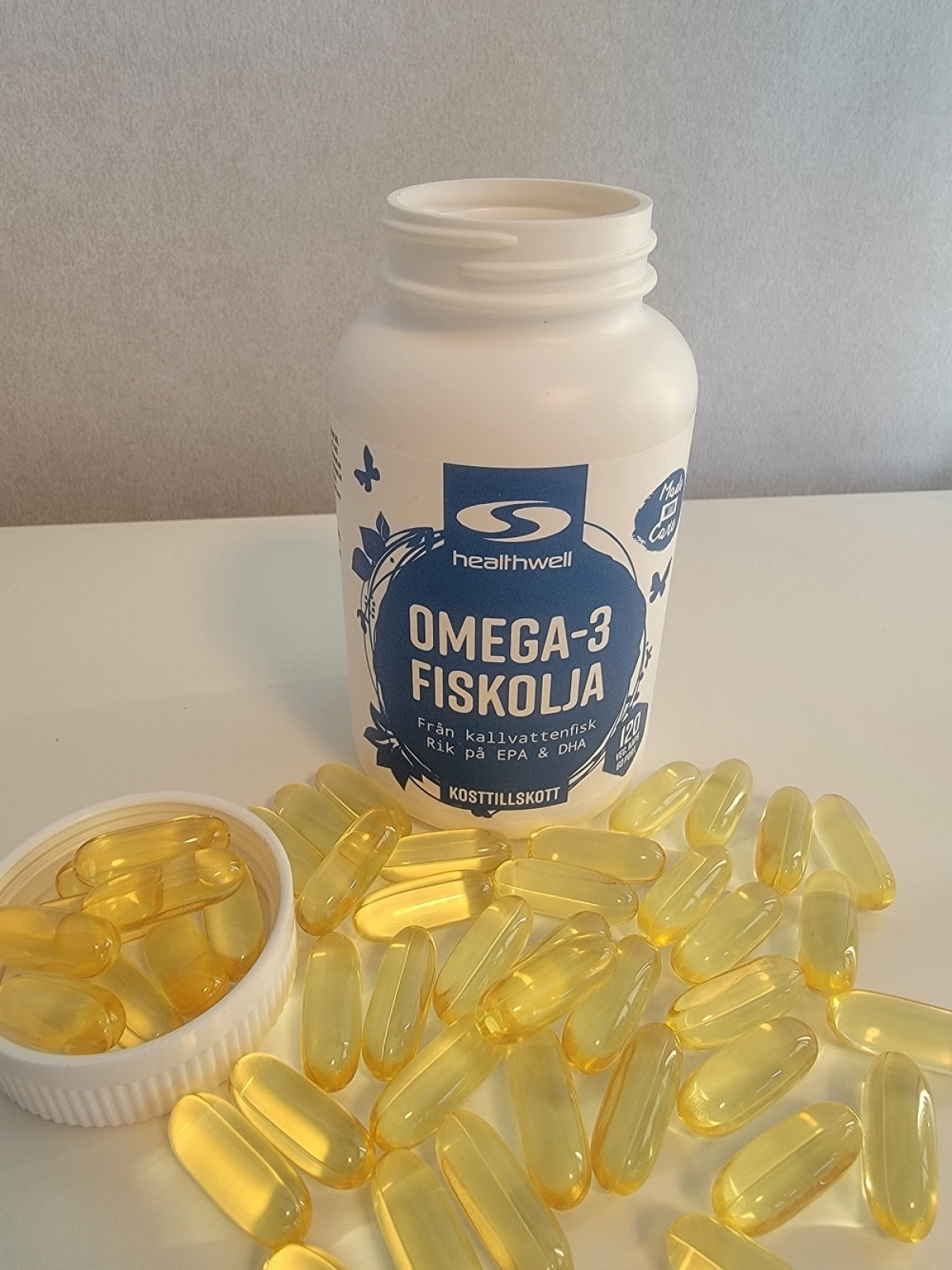 Healthwell Omega-3 Fiskolja fotograferad av oss under testet, öppen burk och kapslar