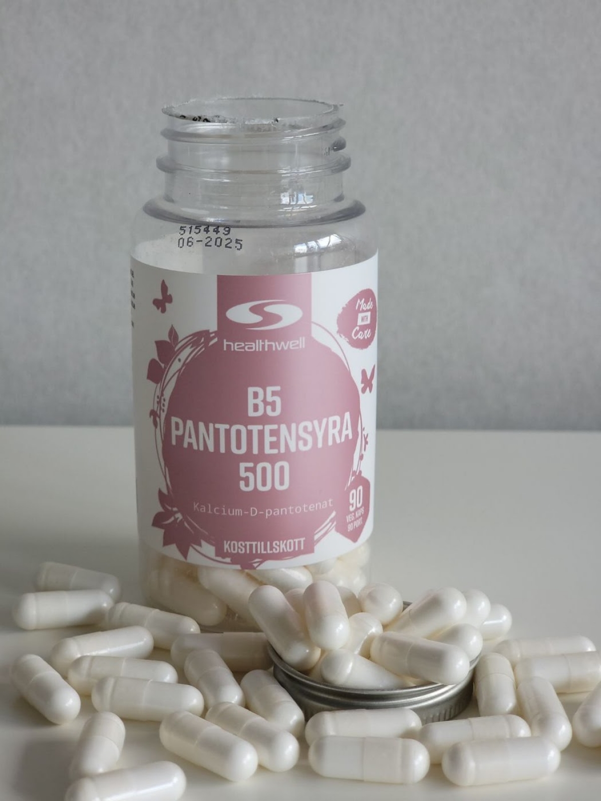 Healthwell B5 Pantotensyra 500 fotograferad av oss under testet, öppen burk och kapslar på bordet