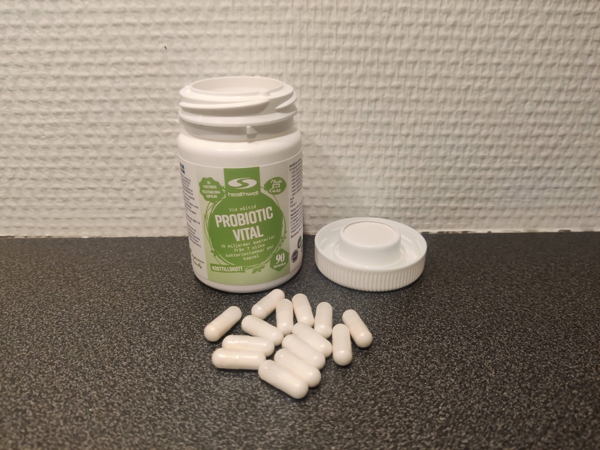 Healthwell Probiotic Vital med öppnad burk och kapslar på bänkskiva, foto taget av oss under testet