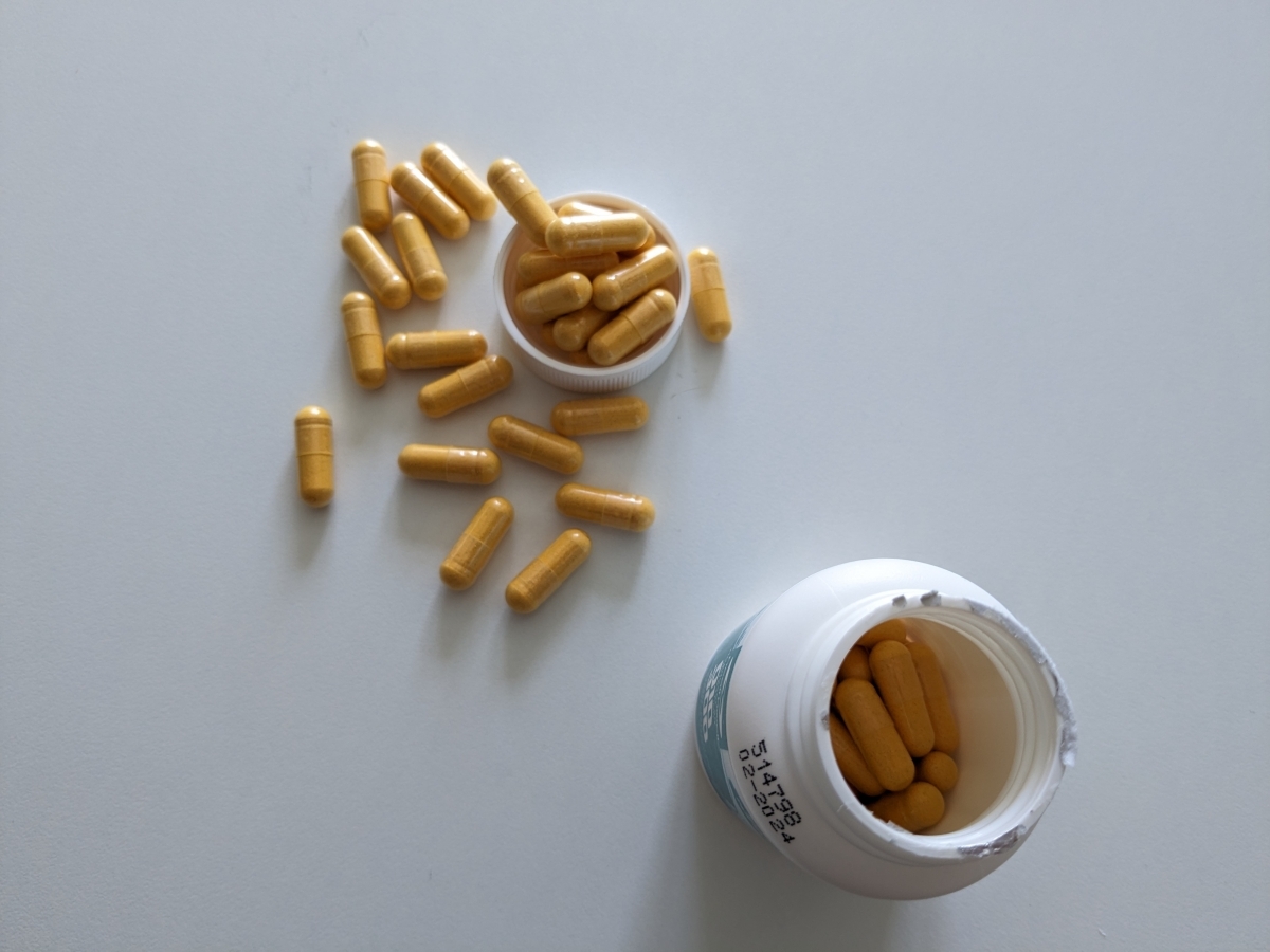Öppnad burk Healthwell Q10 300 med kapslar utlagda på bordet, egen bild från vår testperiod