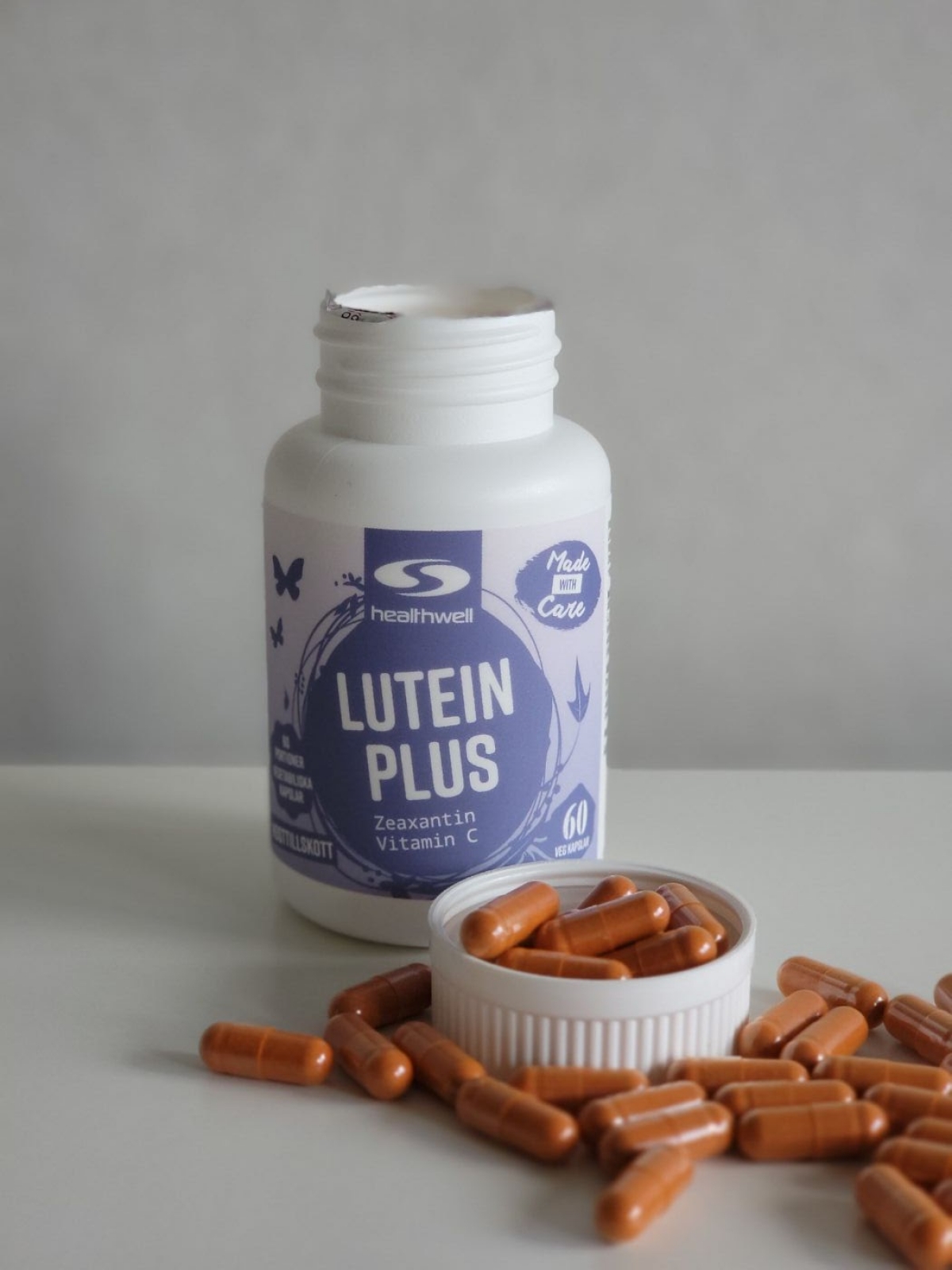 Healthwell Super Lutein fotograferad av oss med öppnad burk och kapslar