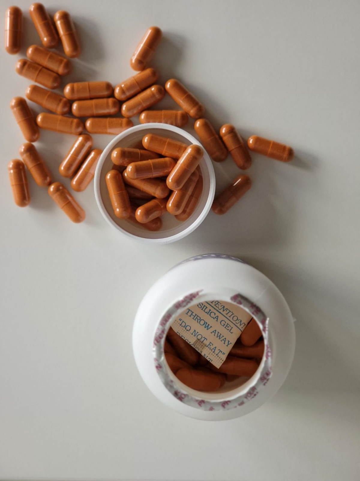 Närbild uppifrån på Healthwell Super Lutein och de orange kapslarna