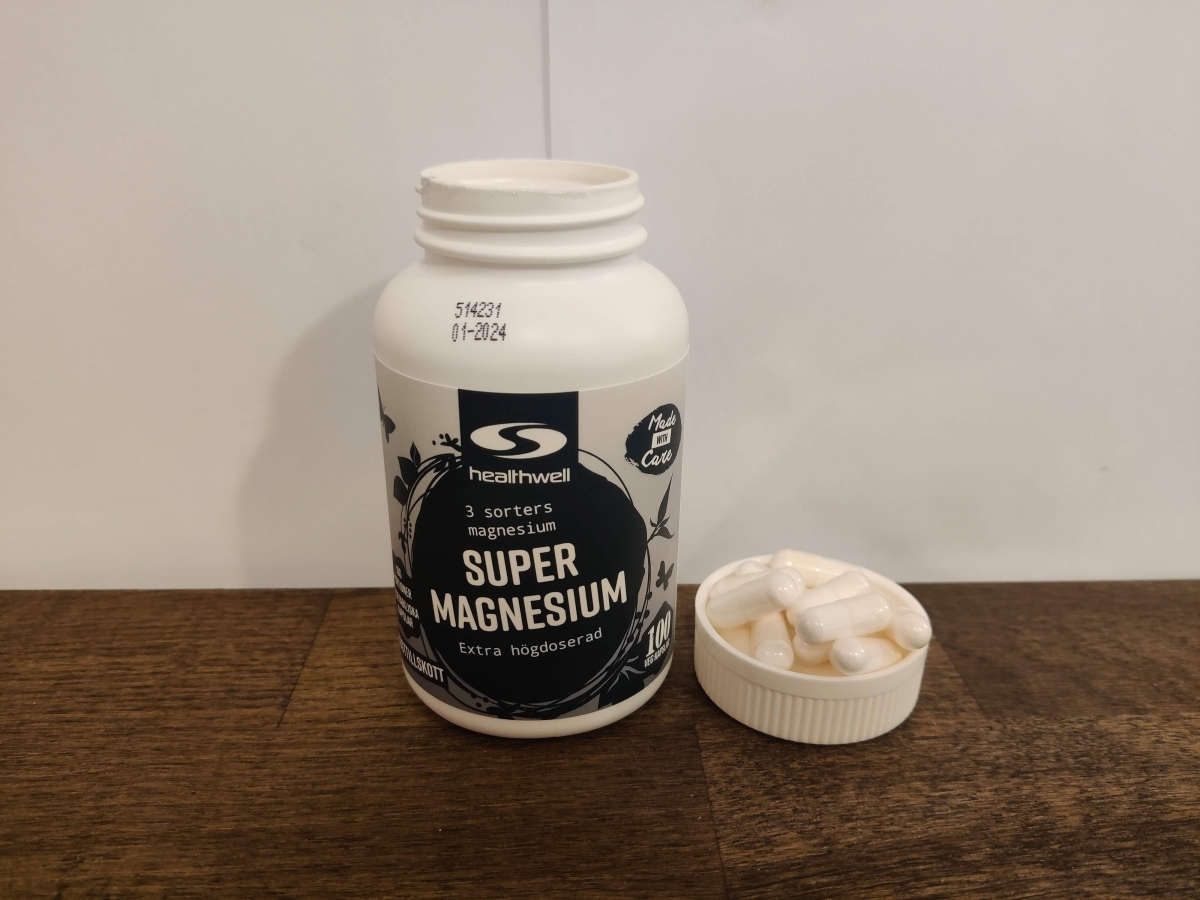 Healthwell Trippel Magnesium i vardagsljus med kapslar bredvid, taget av oss