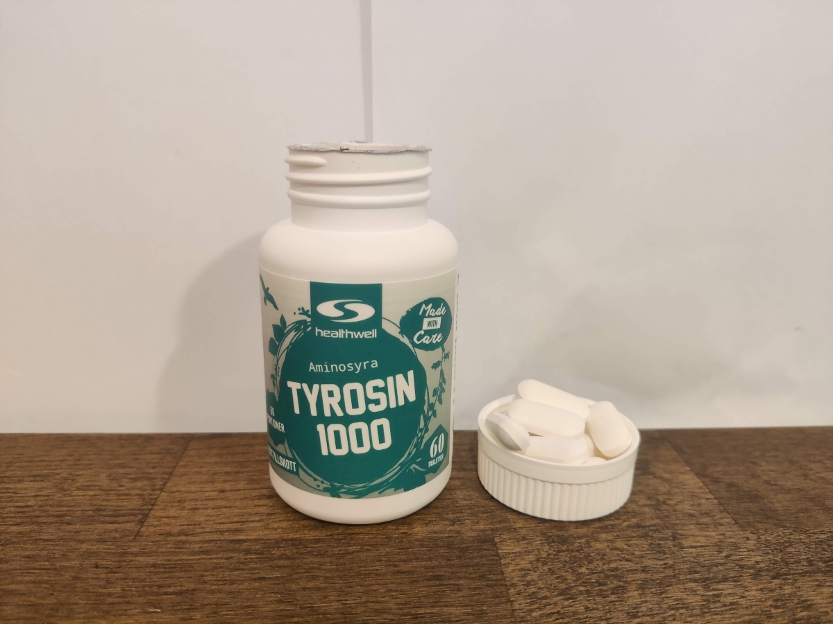 Healthwell Tyrosin 1000 i närbild med några tabletter intill, taget i vårt test