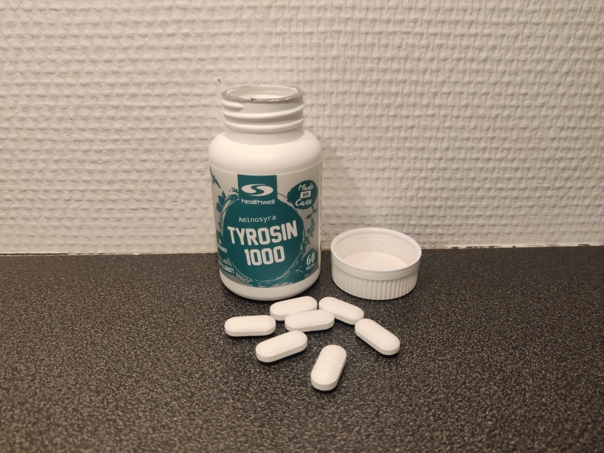 Öppen burk Healthwell Tyrosin 1000 med tabletter framme på bänken