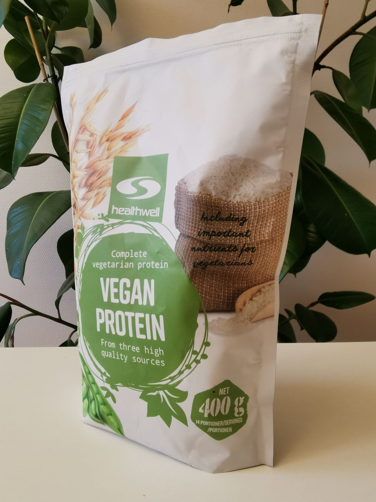 Healthwell Vegan Protein i dagsljus mot gröna blad