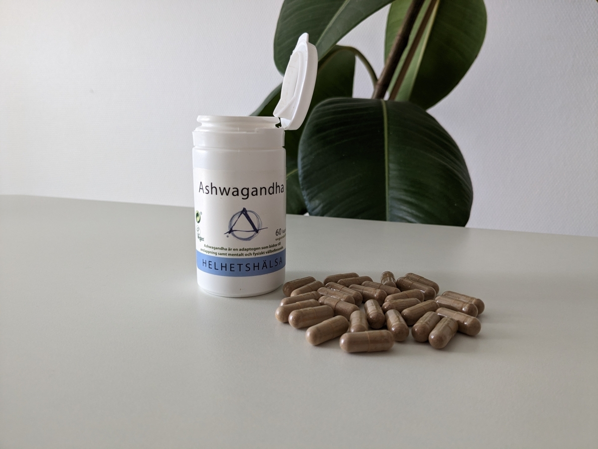 Helhetshälsa Ashwagandha med öppnad burk och kapslar på bord, foto taget av oss under testet