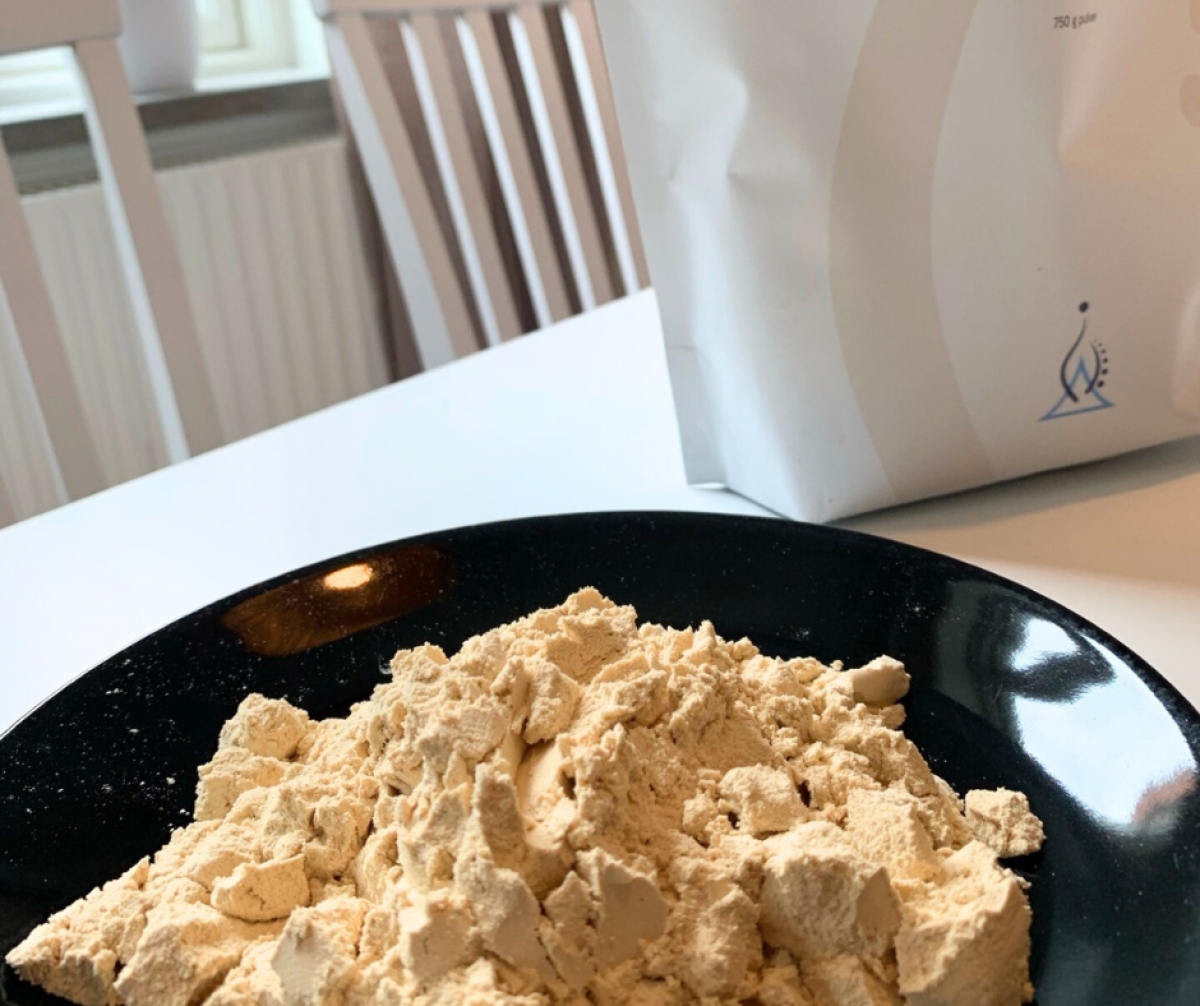 Holistic Ärtprotein upphällt på svart fat, färg och textur i närbild