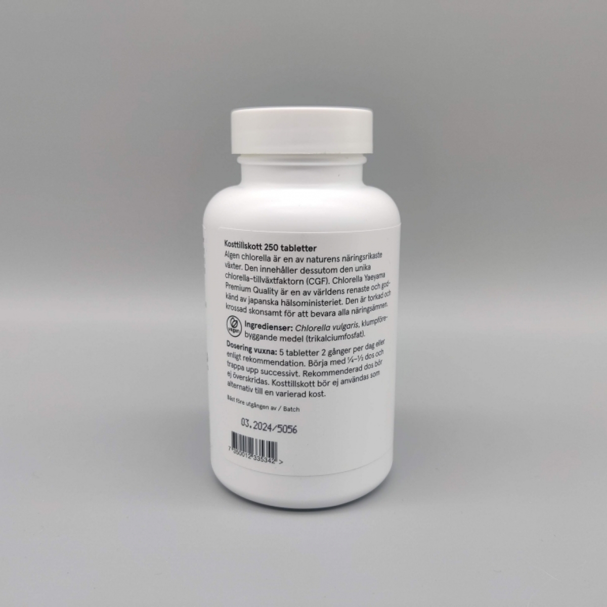 Holistic Chlorella baksida med ingredienser och dosering fotad av oss