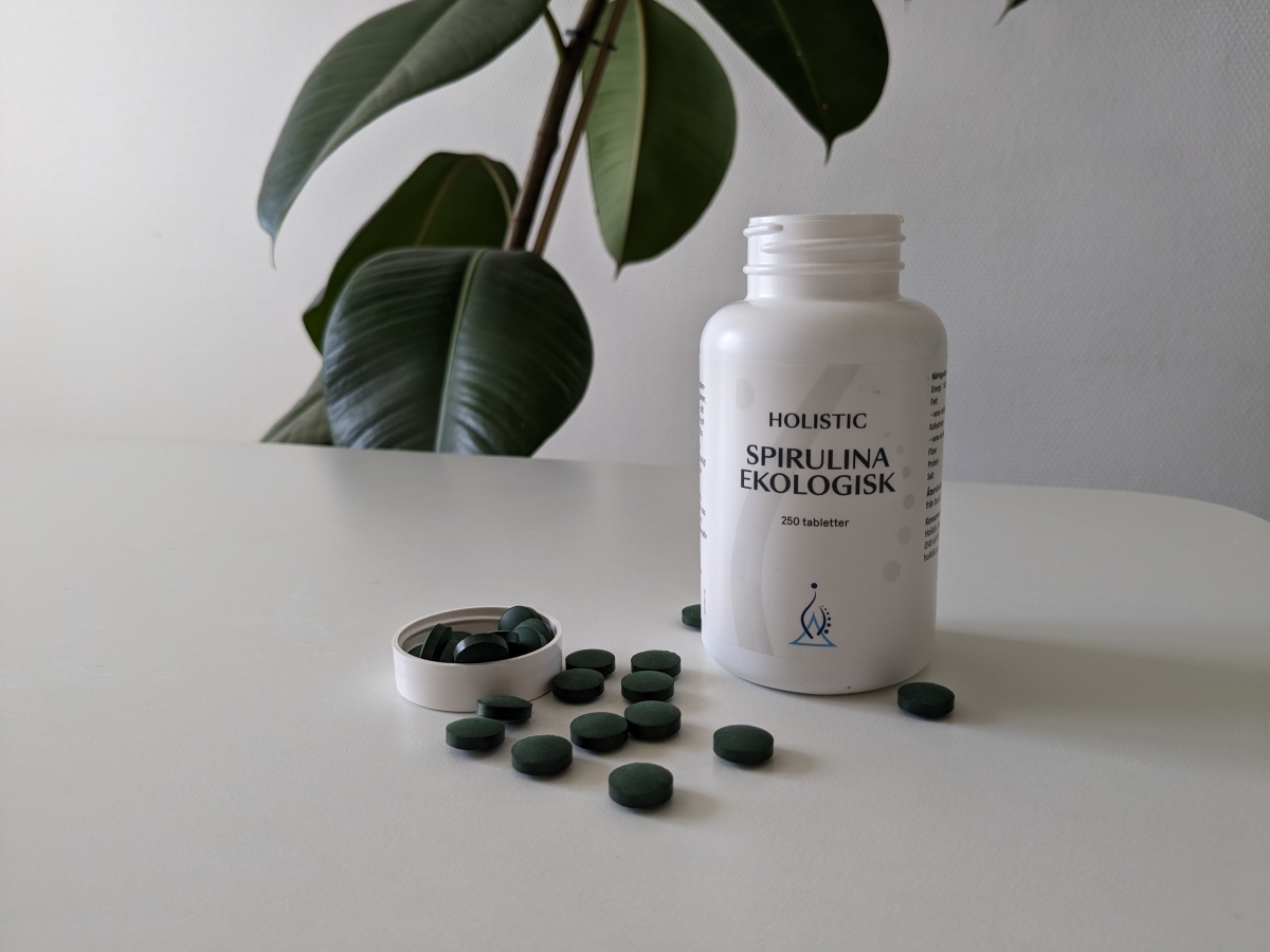 Holistic Spirulina Ekologisk öppnad burk med tabletter på bordet, egen testbild