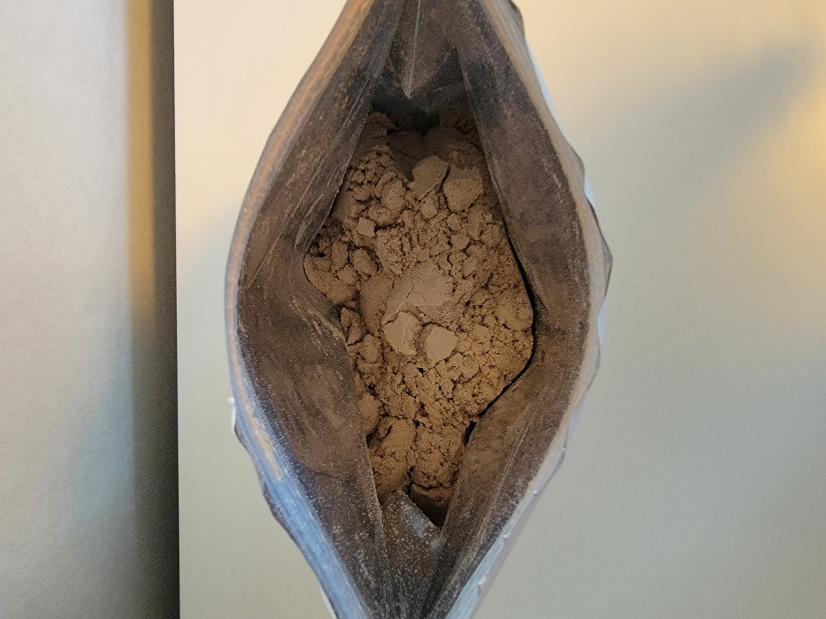 Öppnad påse Holistic Vassleprotein choklad sedd uppifrån, foto från vårt test