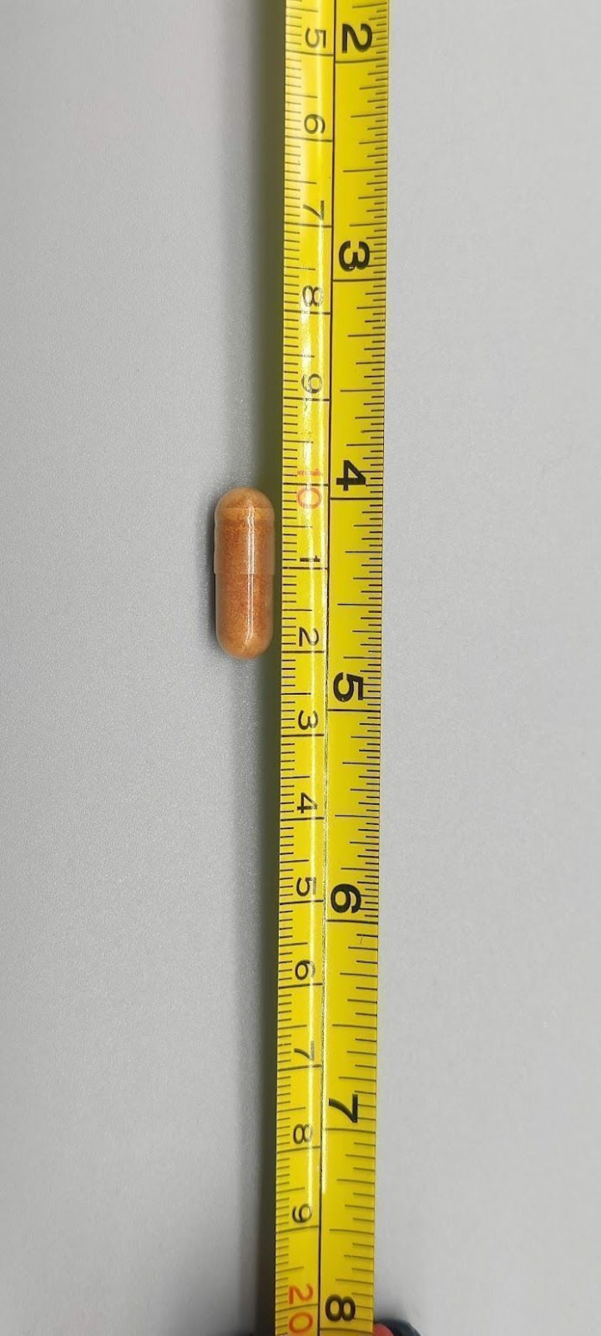 Betakaroten-kapsel mot måttband cirka 2 cm, taget av oss