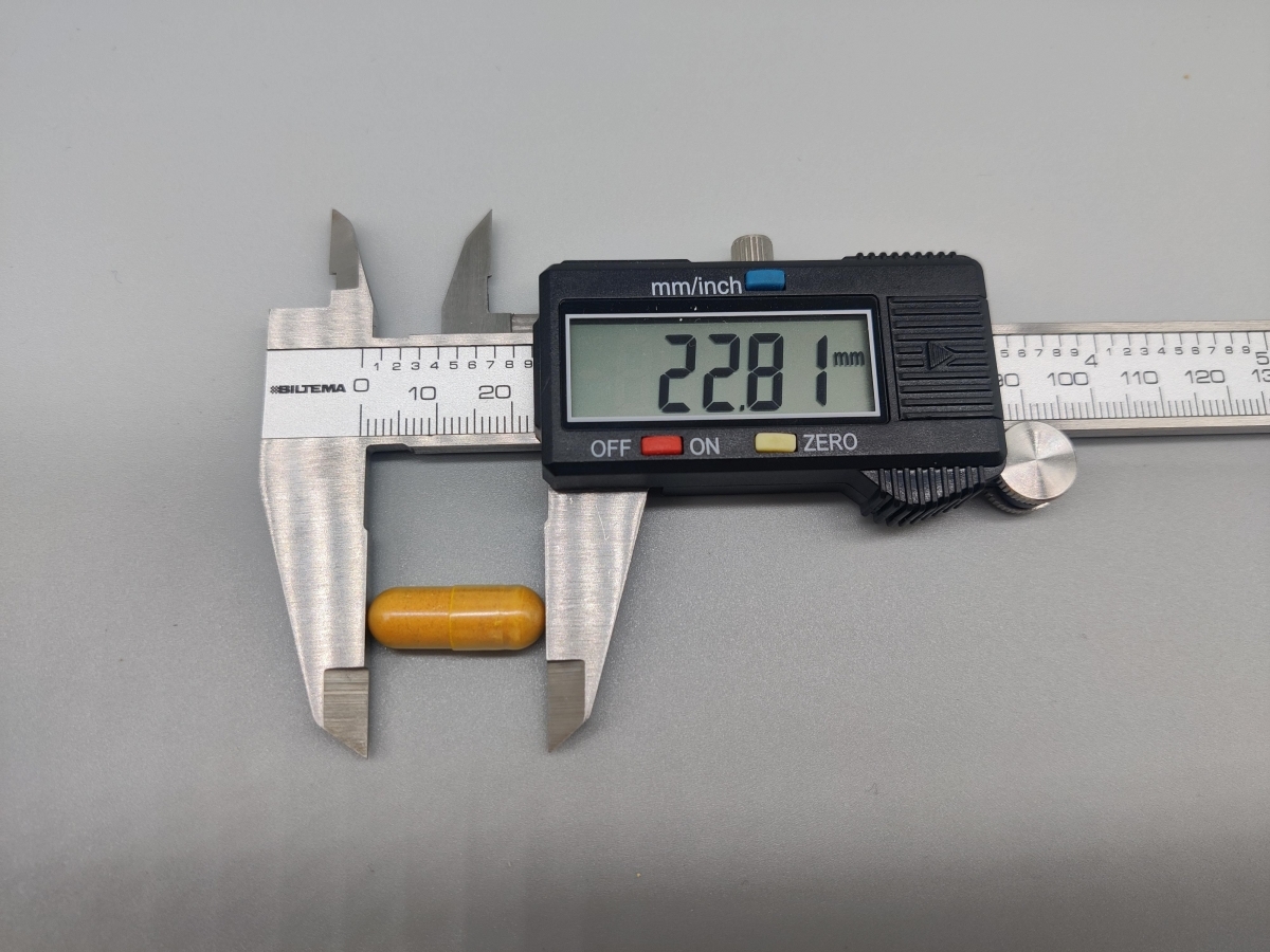 Mätning av kapsel från Inflamin Premium med skjutmått 22,81 mm, fotad av oss