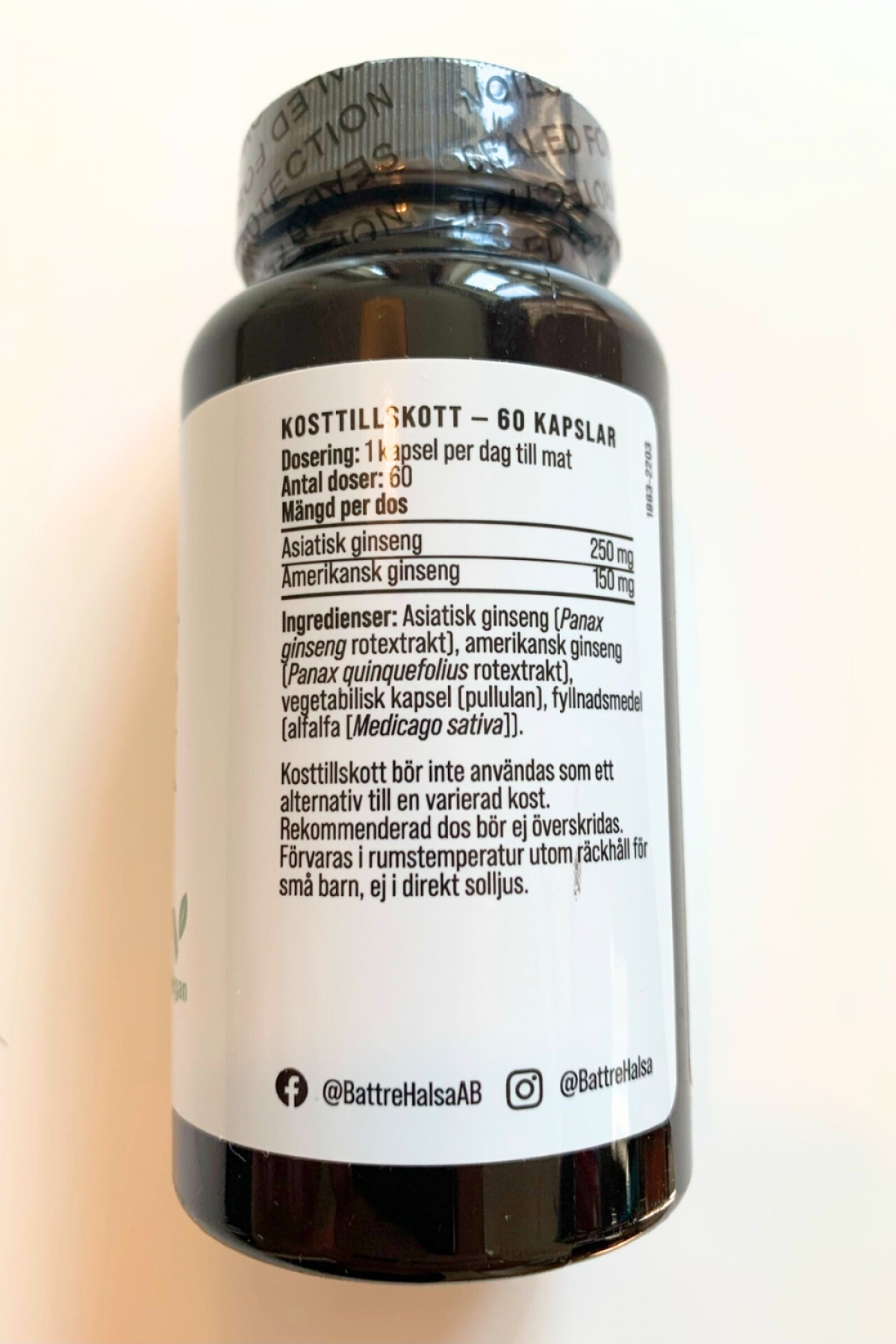 Baksida med dosering och ingredienser 250 mg asiatisk och 150 mg amerikansk ginseng foto taget av oss