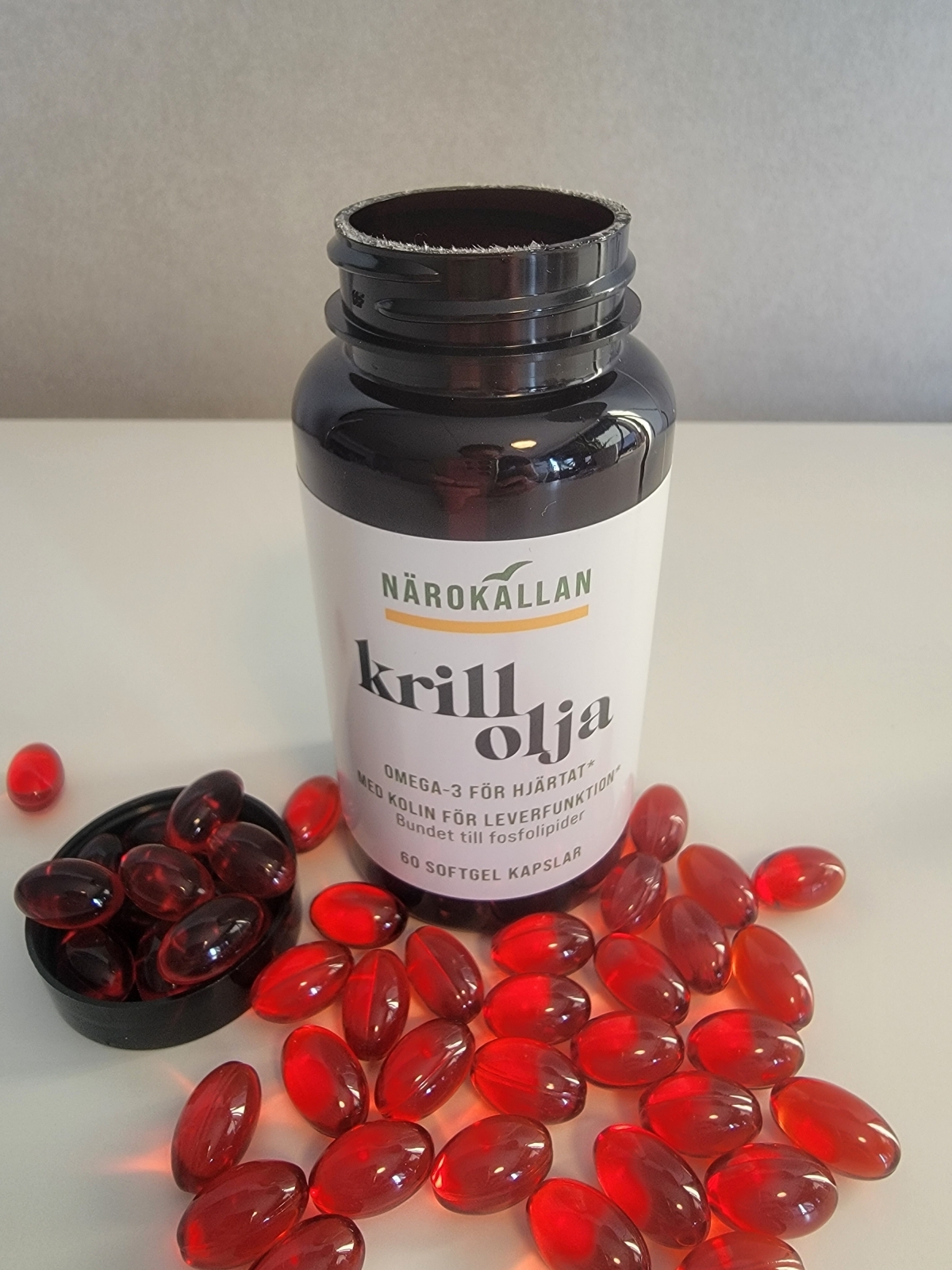 Öppen burk Närokällan Krillolja med röda softgels framför, foto taget av oss under testet