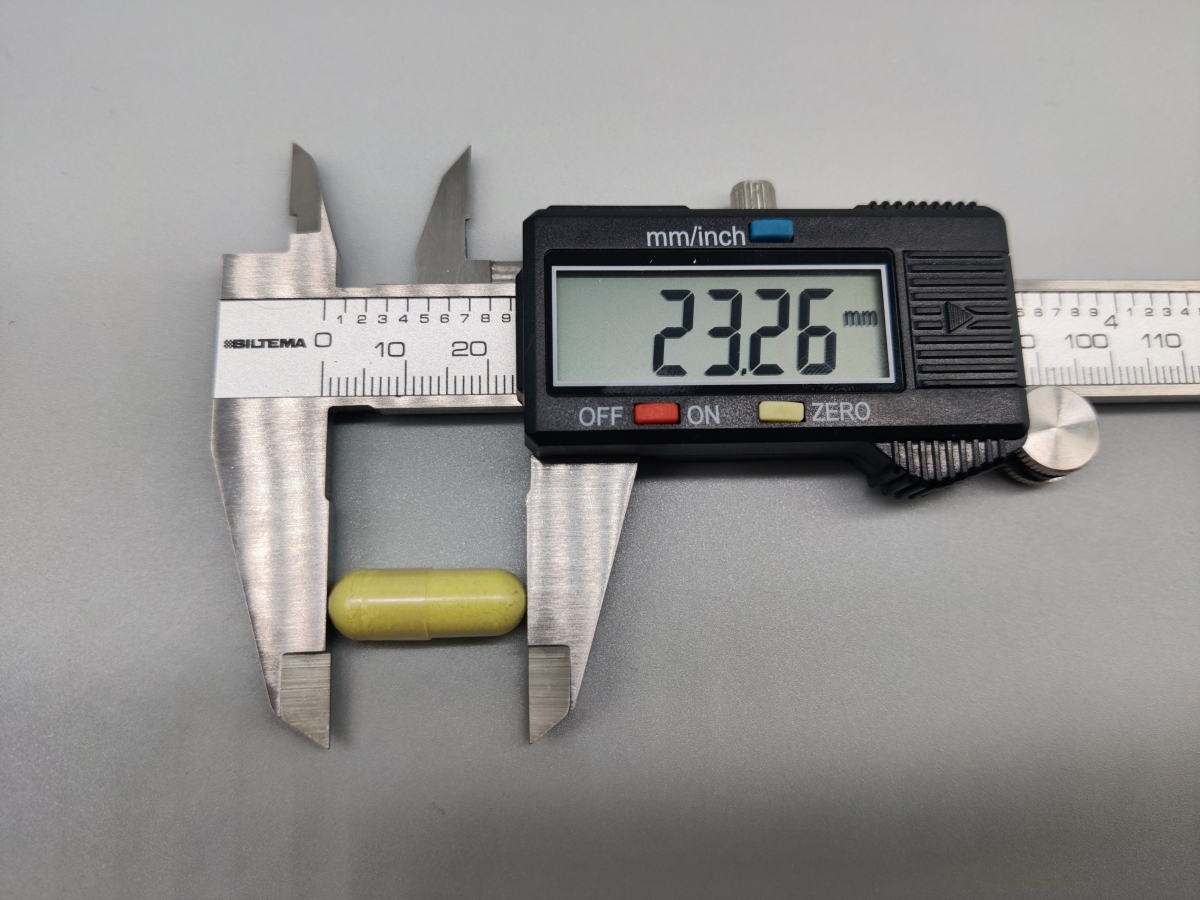 Digitalt skjutmått visar kapsellängd cirka 23,26 mm