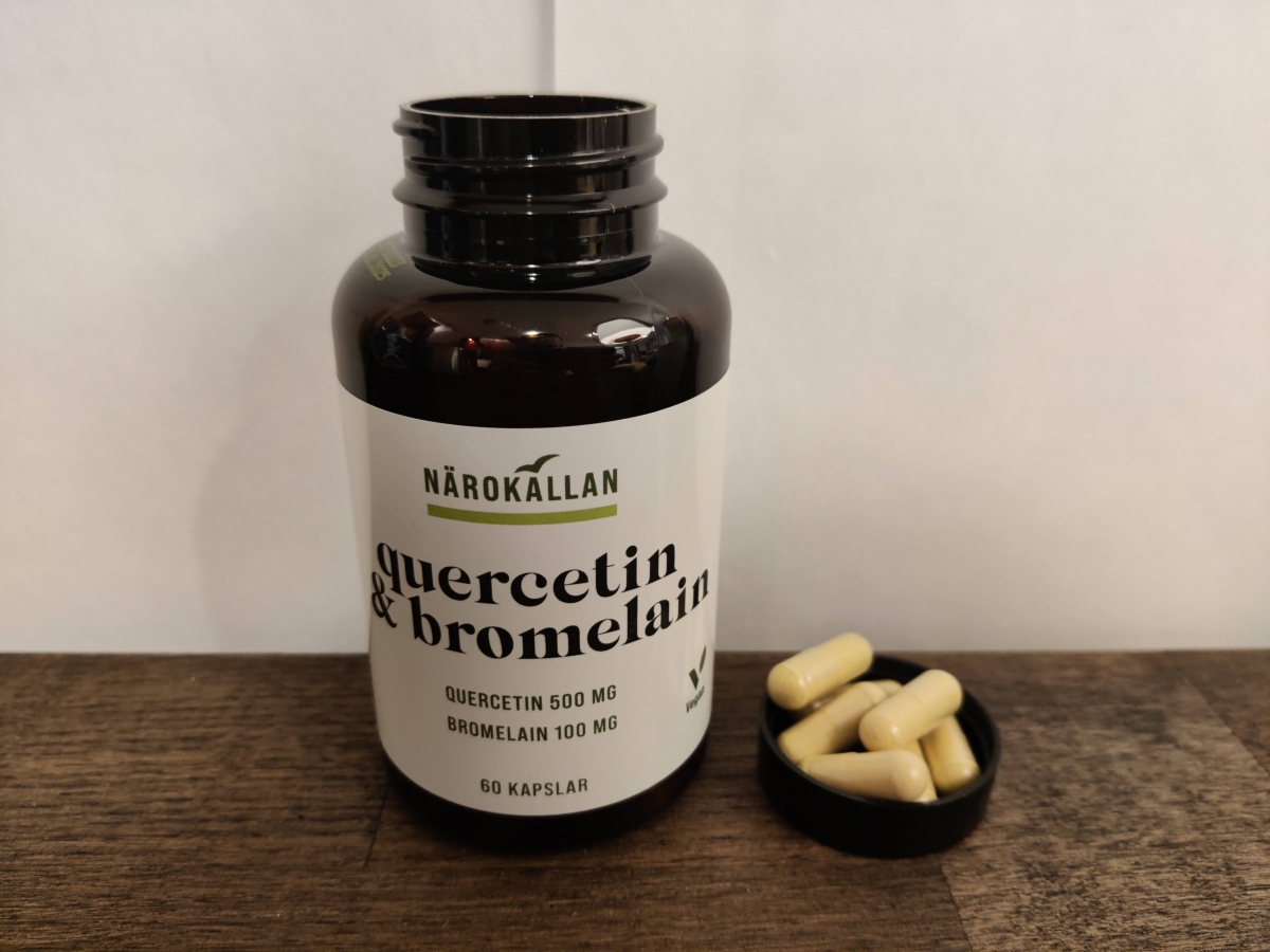 Närbild på Närokällan Quercetin & Bromelain öppnad burk och kapslar intill