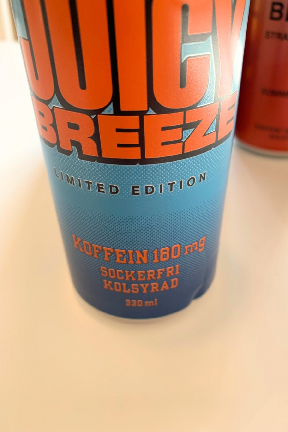 Närbild på NOCCO Juicy Breeze från vårt test med tydlig markering 180 mg koffein sockerfri kolsyrad