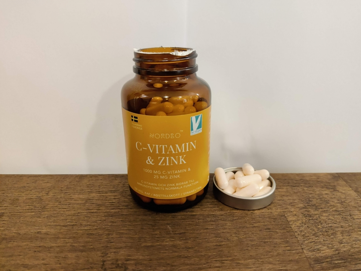Nordbo C‑vitamin & Zink på träbord i dagsljus med kapslar bredvid, taget av oss under testet