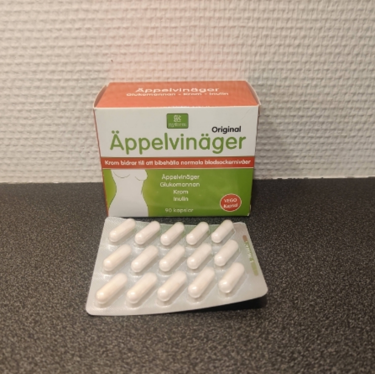 Nyform Äppelvinäger Krom i blister framför förpackningen, foto taget av oss under testet