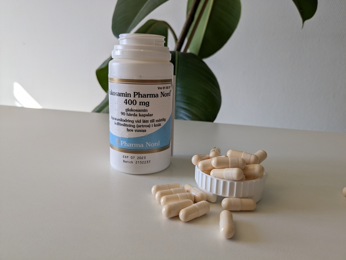 Pharma Nord Glukosamin 400 mg med kapslar på bord i dagsljus, foto av oss under testet