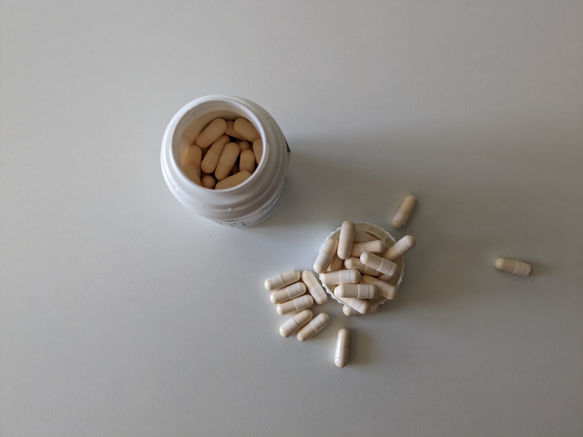 Öppen burk Pharma Nord Glukosamin sedd ovanifrån med kapslar utspridda, fotograferad av oss