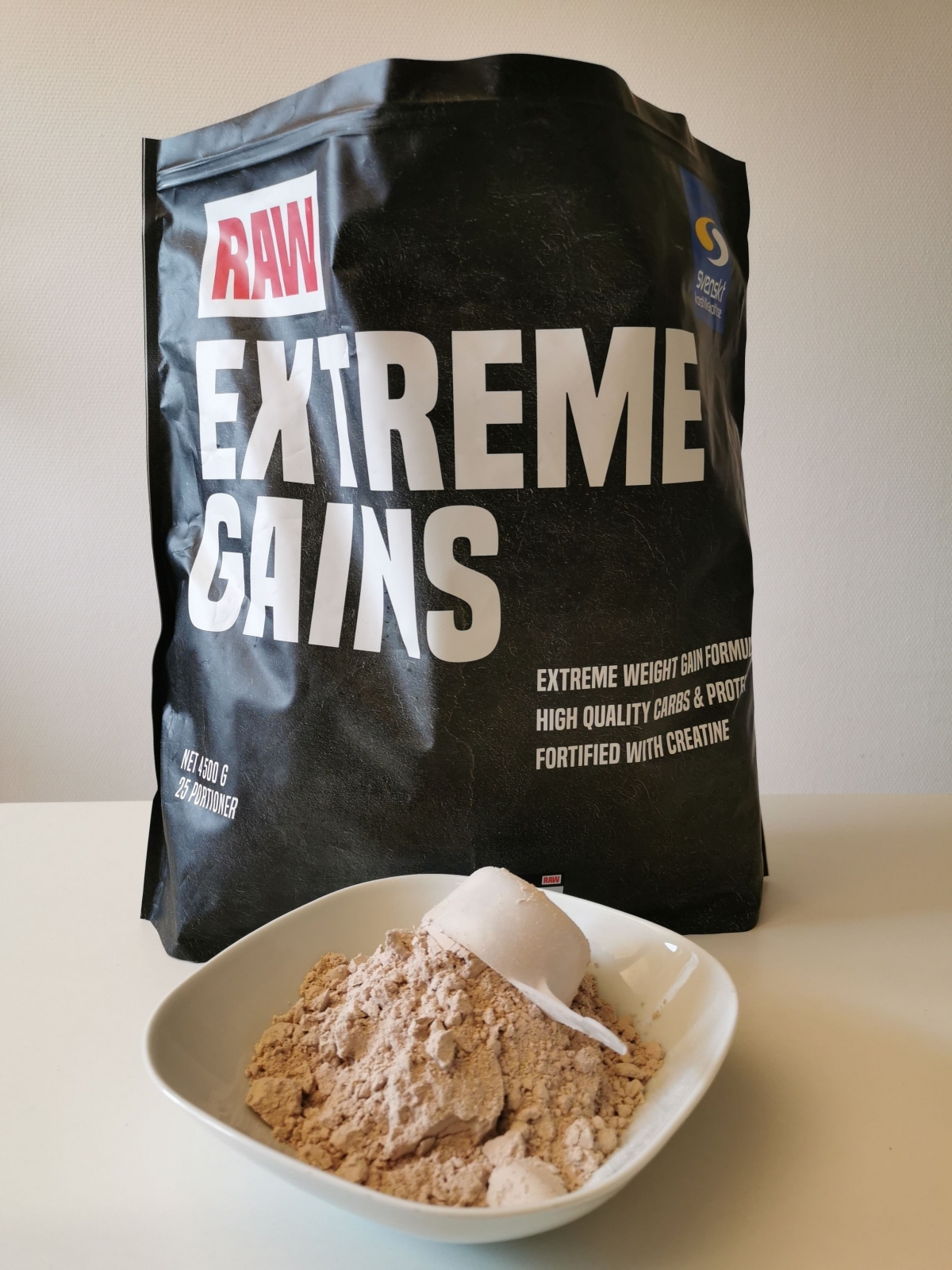 RAW Extreme Gains pulver i skål framför påsen