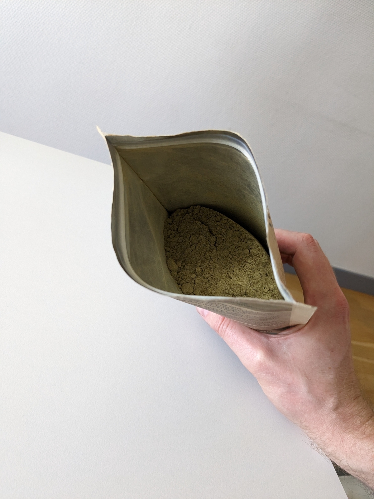 Öppnad påse Rawpowder Hampaprotein EKO med beigegrönt pulver, foto taget av oss under testet