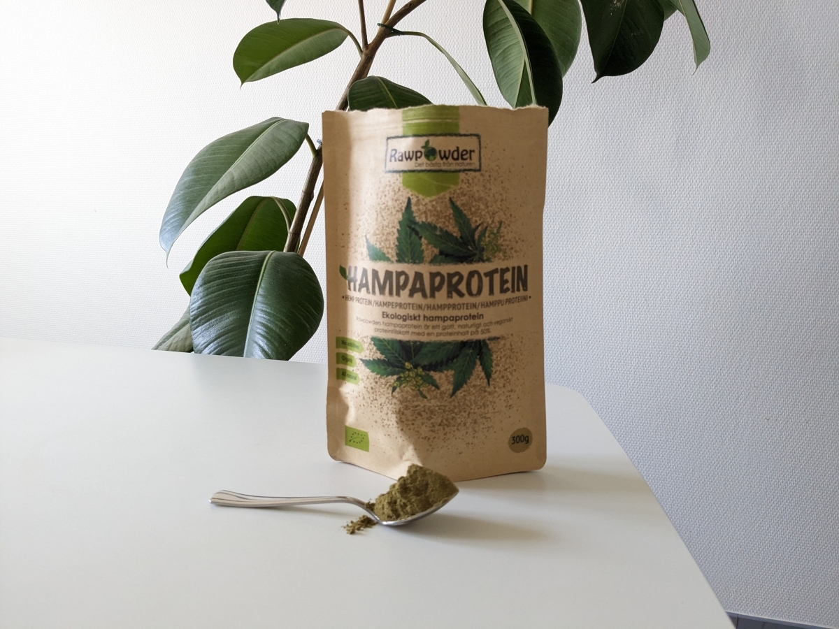 Rawpowder Hampaprotein EKO och en sked pulver på bordet, fotograferat av oss