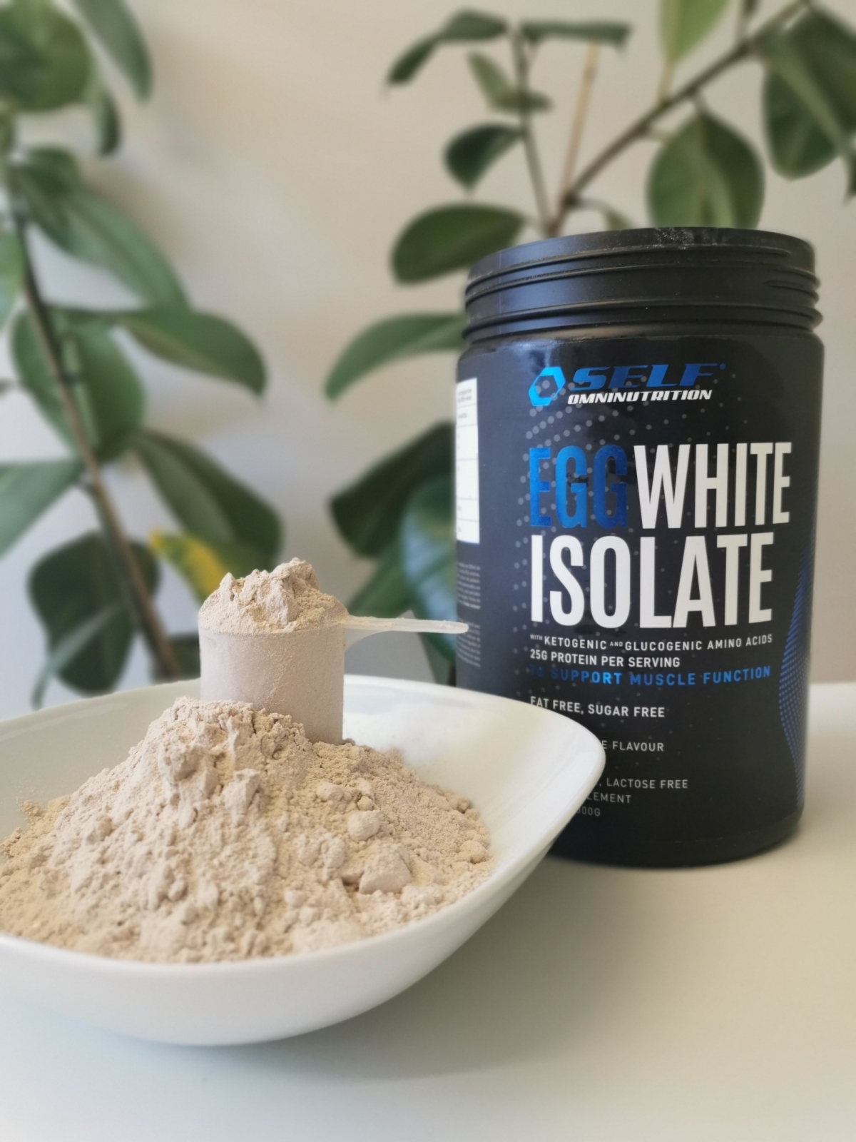 Finkornigt chokladpulver från Self Egg White Isolate upphällt i skål med skopa, egen bild
