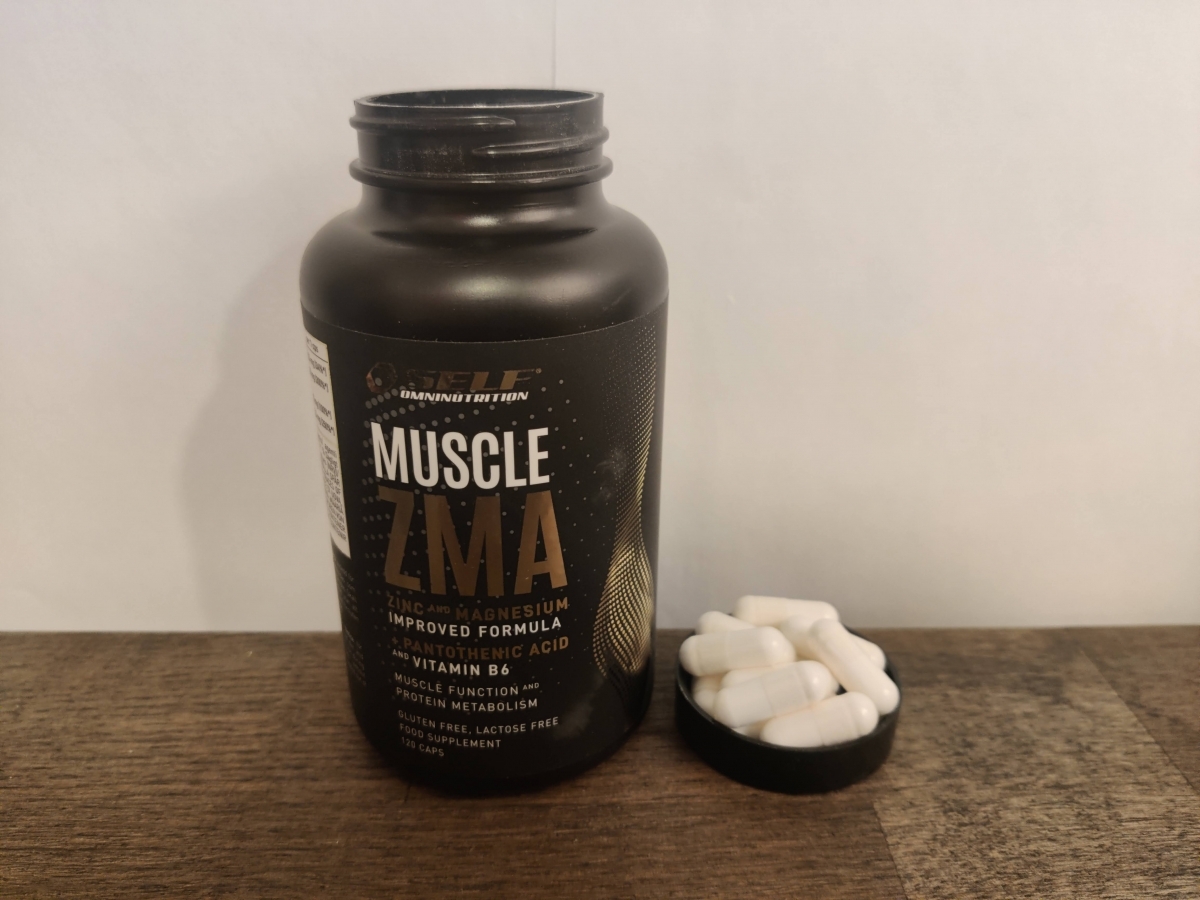 ZMA-burken i närbild med några kapslar bredvid på träbord, vår egen produktbild