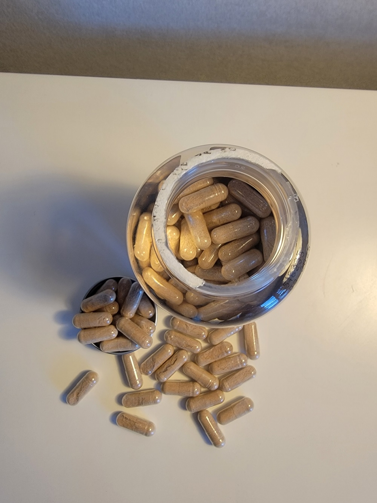 Öppnad burk Silica Beauty Caps med kapslar utspridda på bordet, foto av oss under testet