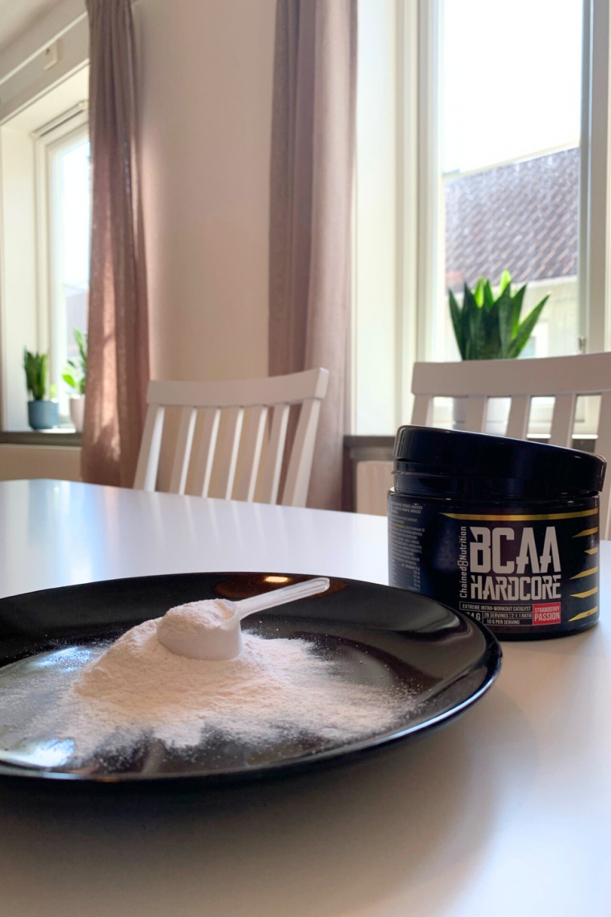 Skopa med BCAA-pulver på tallrik och burken i bakgrunden, foto från testet