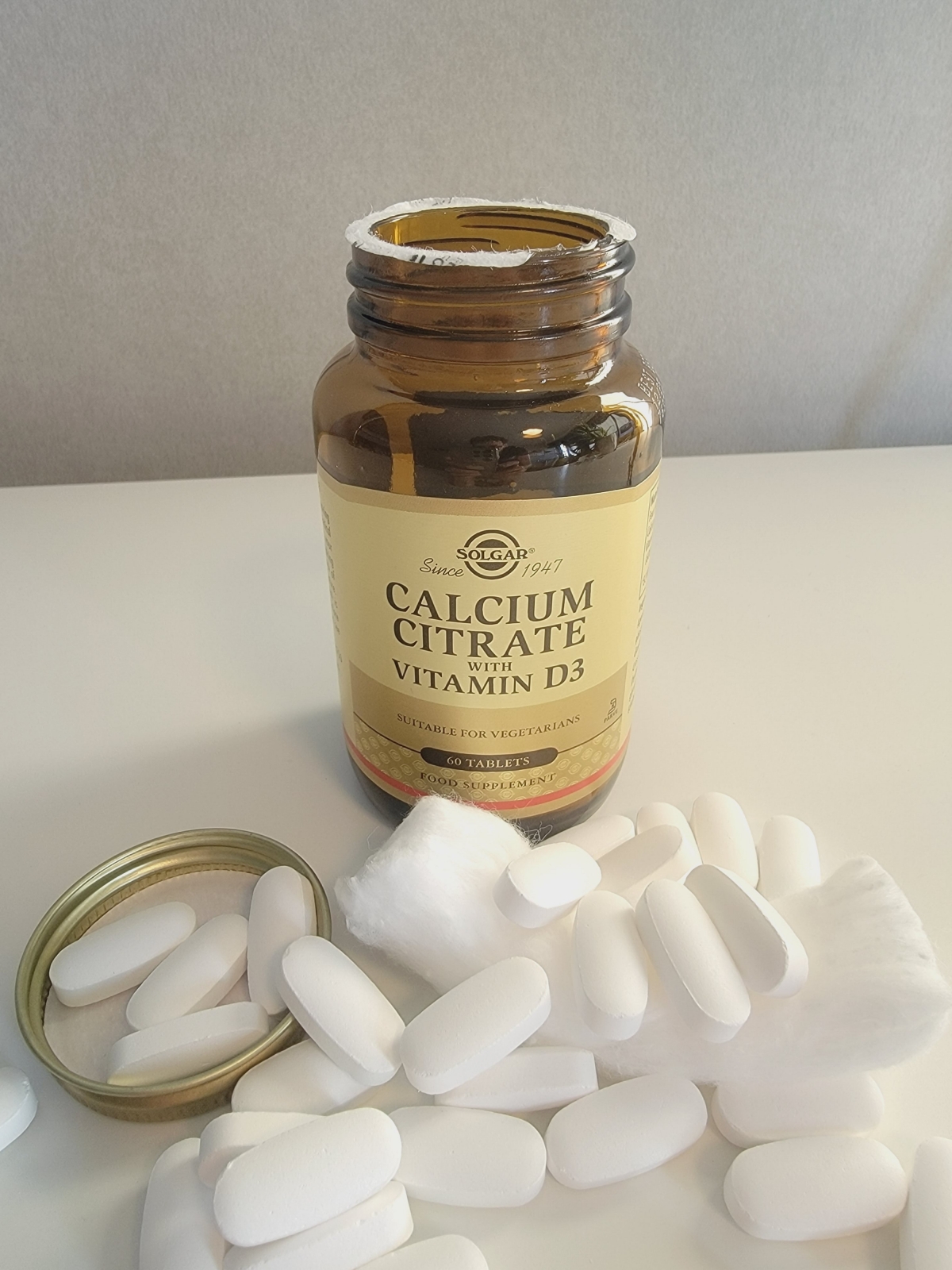 Eget foto av Solgar Calcium Citrate med D3 – öppnad glasburk och släta tabletter