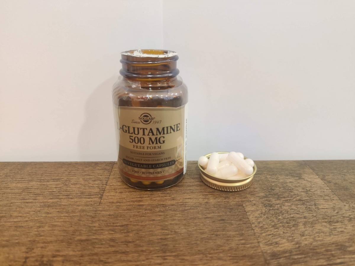 Öppen burk med Solgar L-Glutamine och kapslar bredvid, fotograferat av oss
