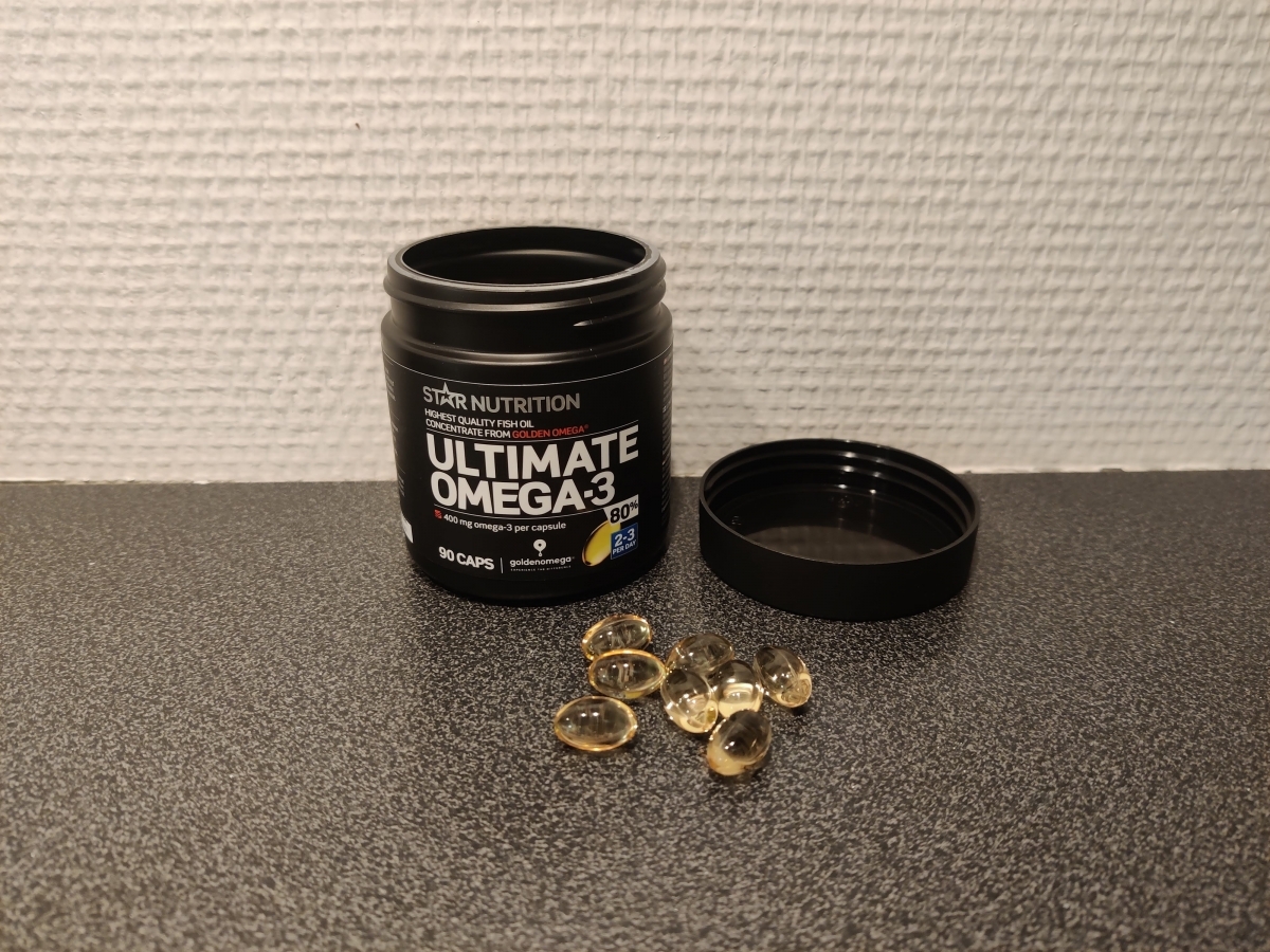 Kapslar bredvid burken på köksbänken under vårt test av Ultimate Omega-3 80 procent