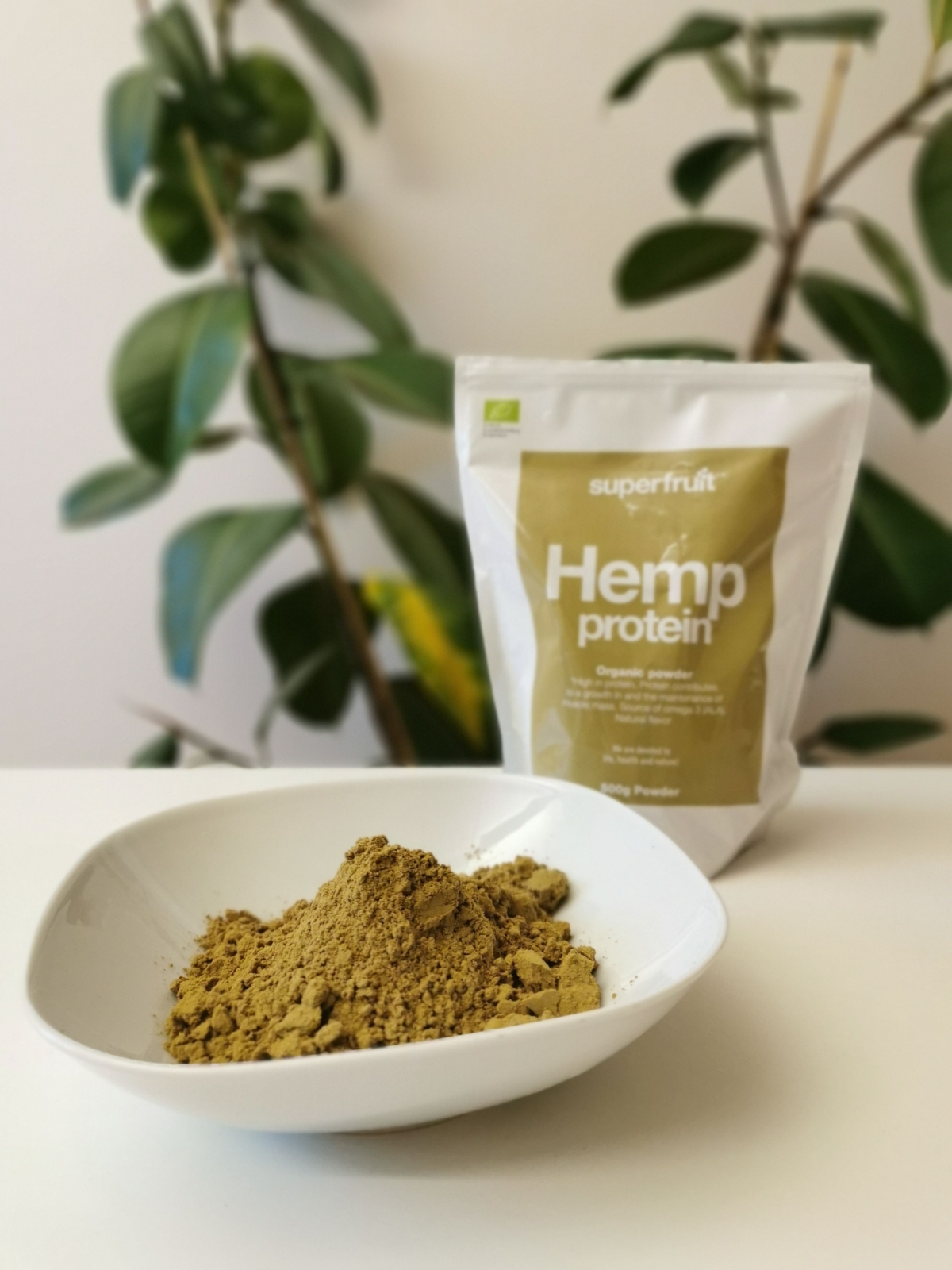 Hampaproteinpulver i skål med Superfruit-påsen i bakgrunden fotograferad av oss under testet