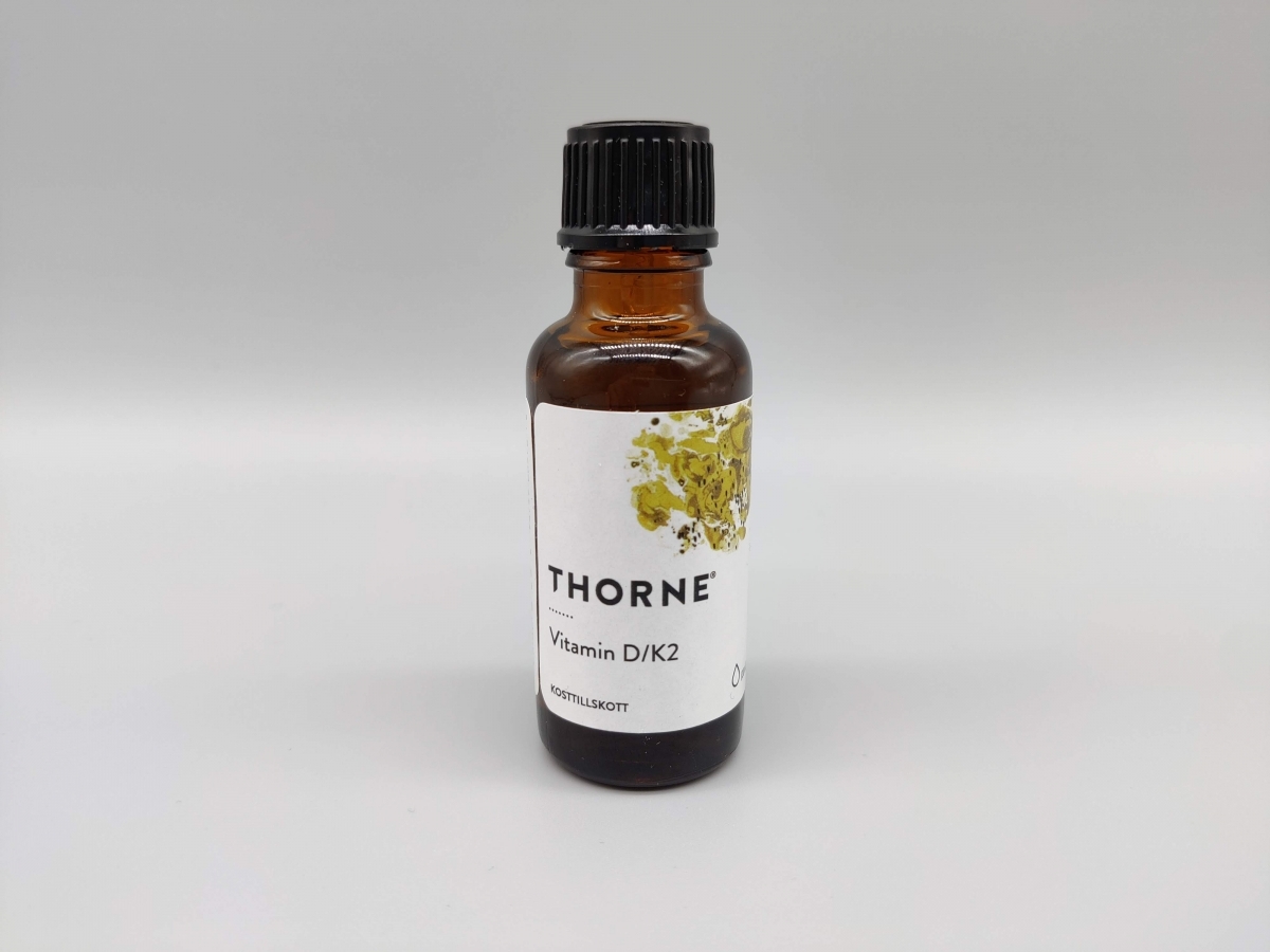 Thorne <a href='https://www.kostnord.se/kosttillskott/d-vitamin'>Vitamin D</a> K2 flaska mot ljus bakgrund vårt eget produktfoto