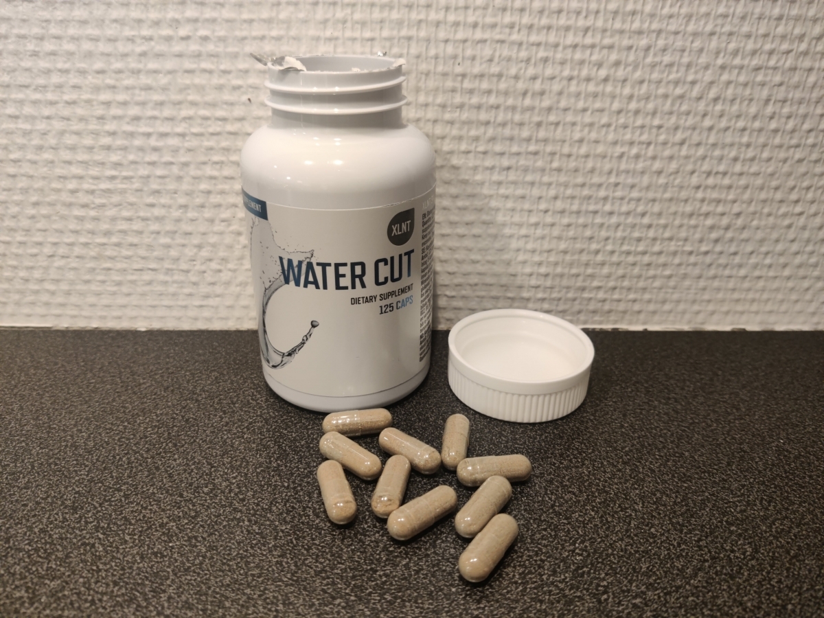 XLNT Sports Water Cut öppnad med kapslar på bänken, foto taget av oss under testet