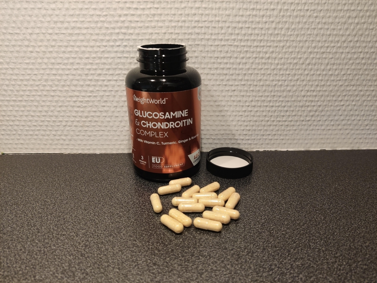 Weight World Glukosamin fotograferad av oss under testet, öppen burk och kapslar på bänkskiva