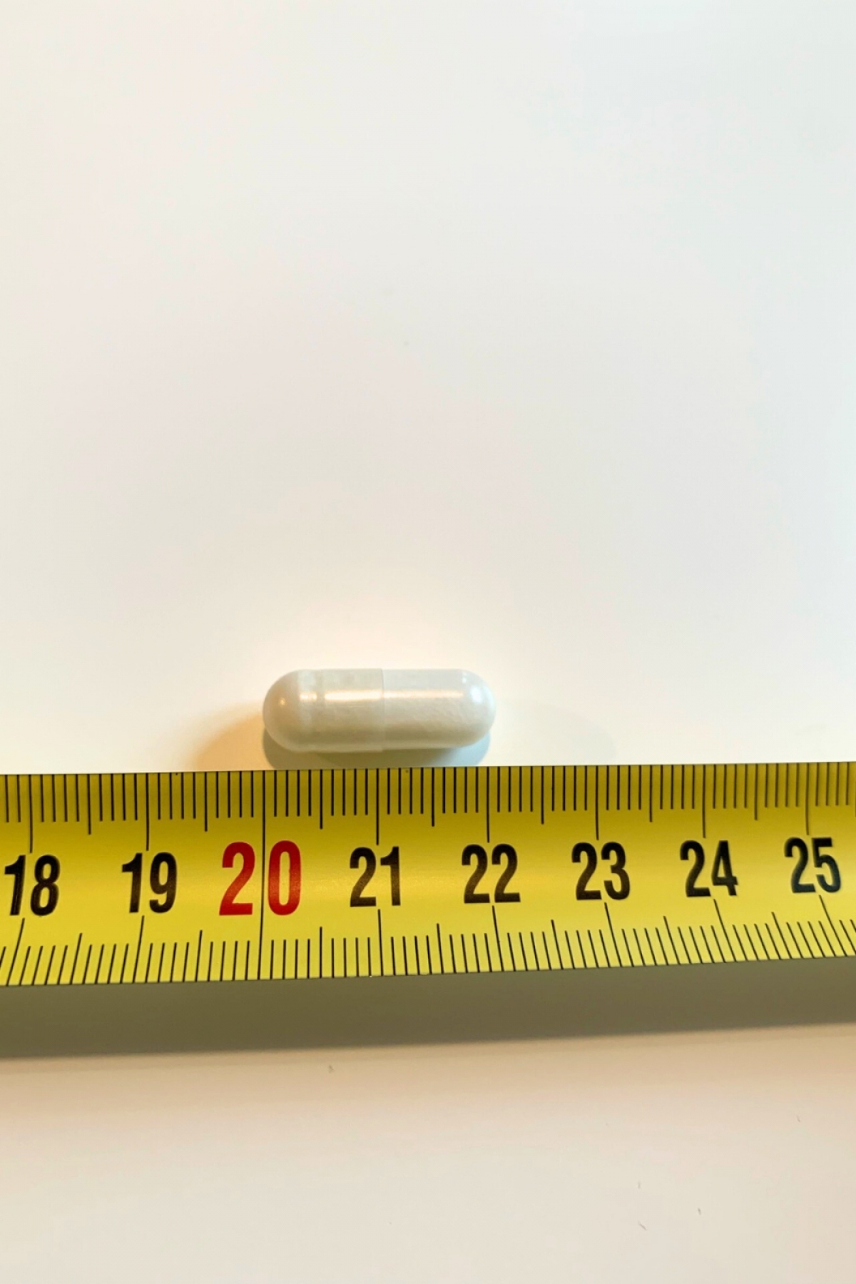En kapsel från ZMA Night bredvid måttband, cirka 20 mm lång