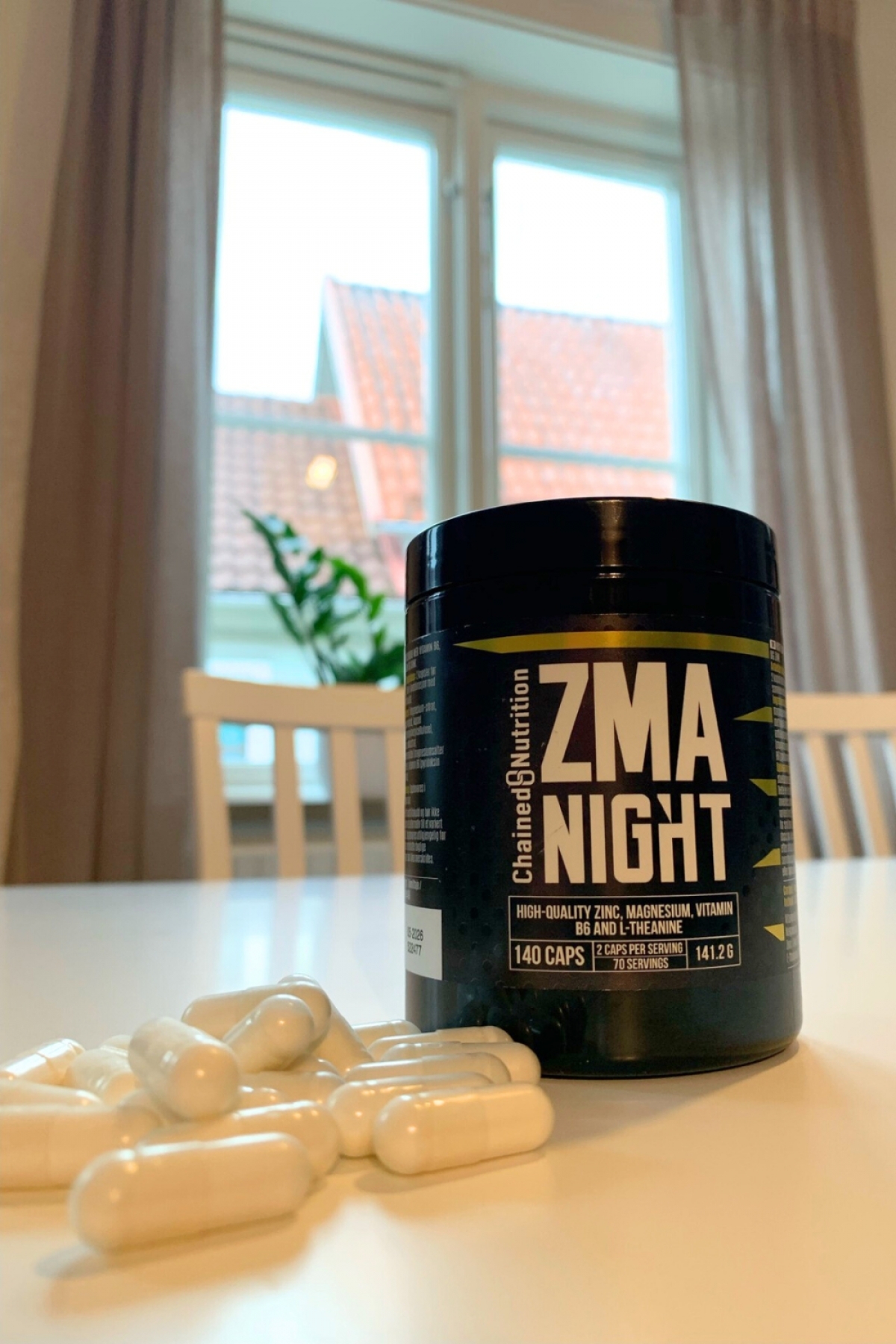 Vita kapslar framme på bordet bredvid ZMA Night-burken